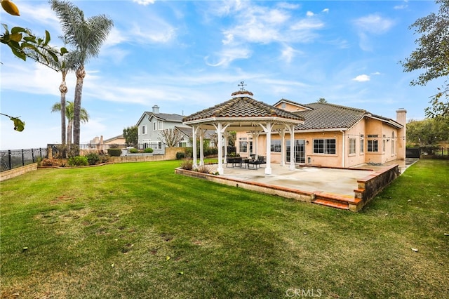 back of property with a gazebo, a yard, and a patio area