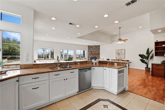 kitchen featuring white cabinetry, kitchen peninsula, dark stone counters, and dishwasher