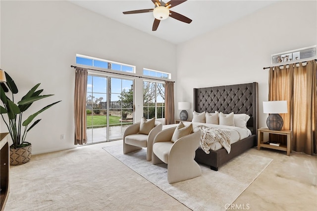 bedroom with light carpet, a towering ceiling, access to outside, and ceiling fan