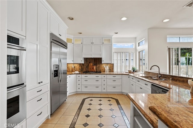 kitchen with stainless steel appliances, light stone countertops, and white cabinets