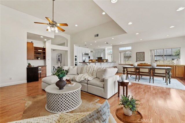 living room with ceiling fan and light hardwood / wood-style floors