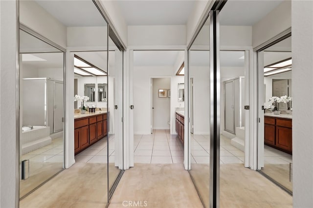 bathroom with tile patterned flooring, vanity, and walk in shower