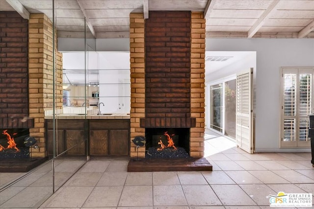 unfurnished living room featuring sink, wood ceiling, light tile patterned floors, beamed ceiling, and a fireplace