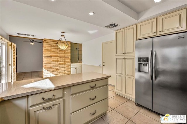 kitchen featuring pendant lighting, stainless steel fridge with ice dispenser, and cream cabinetry