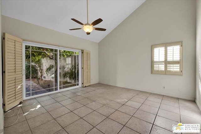 tiled empty room with ceiling fan and high vaulted ceiling