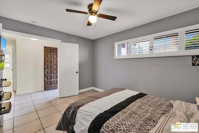 tiled bedroom featuring multiple windows and ceiling fan