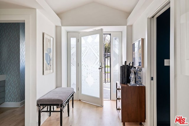 foyer entrance with lofted ceiling and light hardwood / wood-style floors