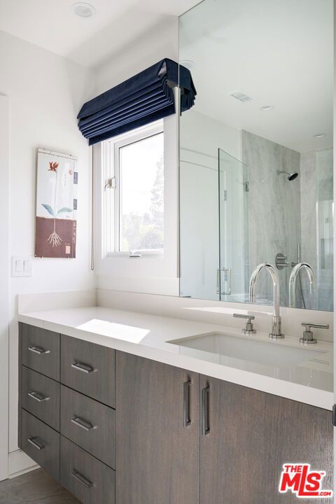 bathroom with vanity and tiled shower