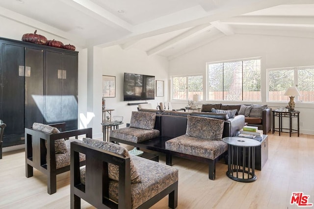 living room with hardwood / wood-style floors, a wealth of natural light, and vaulted ceiling with beams