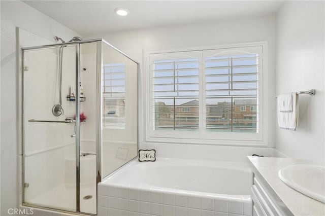 full bathroom featuring a bath, a stall shower, vanity, and a wealth of natural light