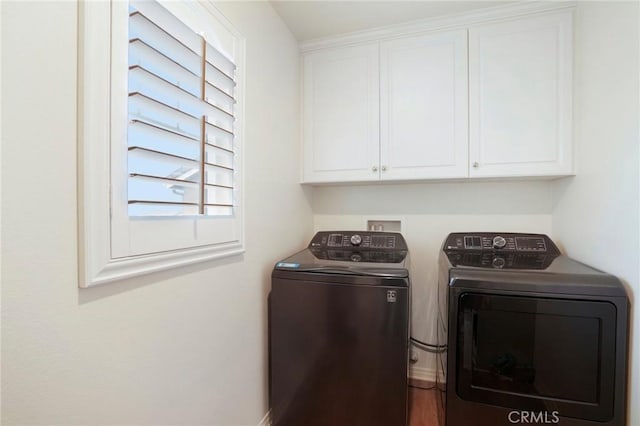 clothes washing area with washer and clothes dryer and cabinet space