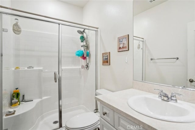 full bath featuring toilet, a stall shower, and vanity