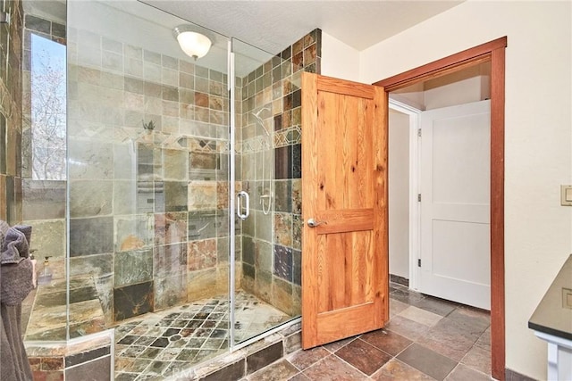 full bath featuring stone finish floor and a shower stall