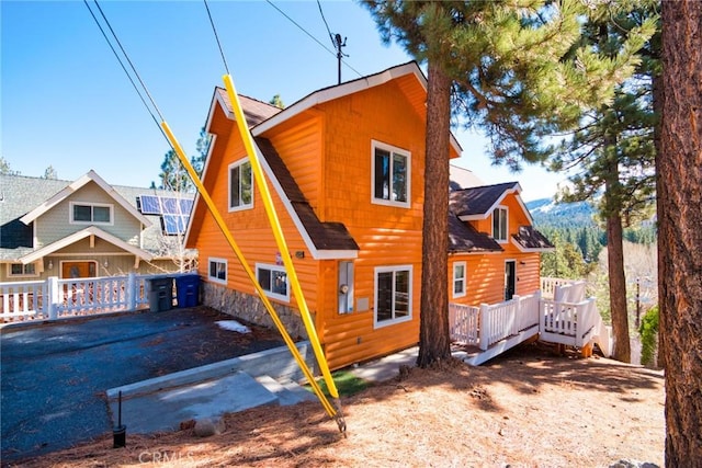 back of house featuring a wooden deck and faux log siding