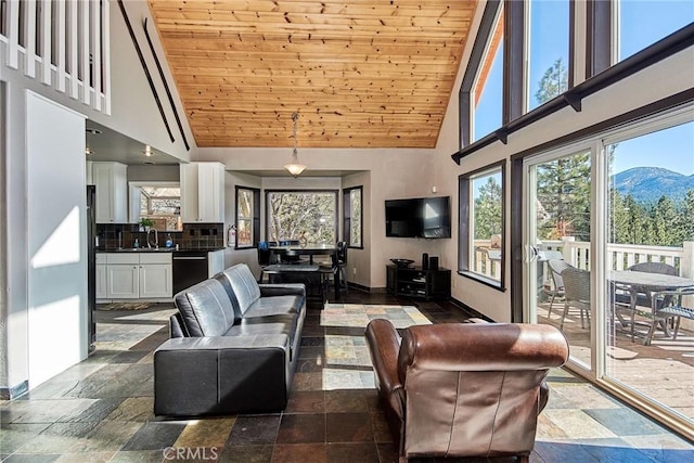 living area featuring high vaulted ceiling, wood ceiling, baseboards, and stone tile floors