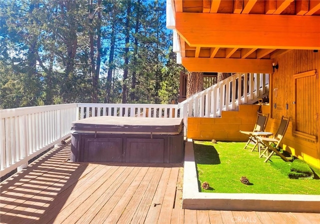 wooden terrace featuring a hot tub and a yard