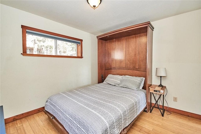 bedroom with wood-type flooring and baseboards