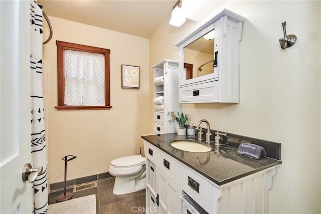 bathroom featuring toilet, visible vents, vanity, and baseboards