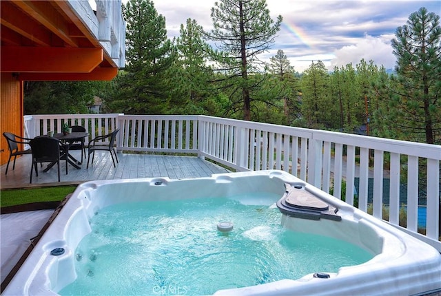 deck featuring a water view and a hot tub