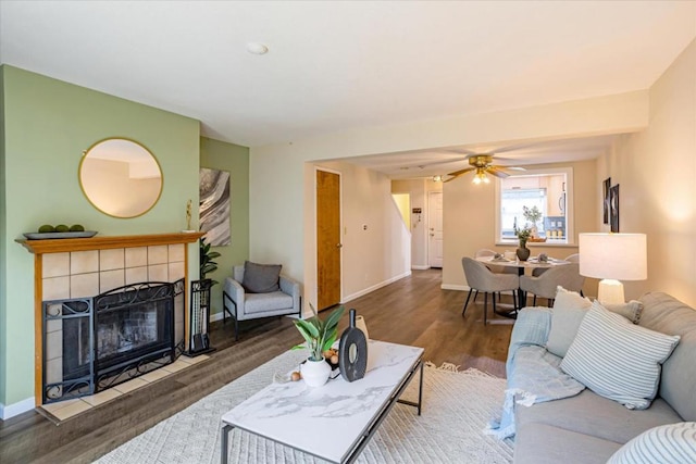 living room featuring ceiling fan, hardwood / wood-style floors, and a fireplace