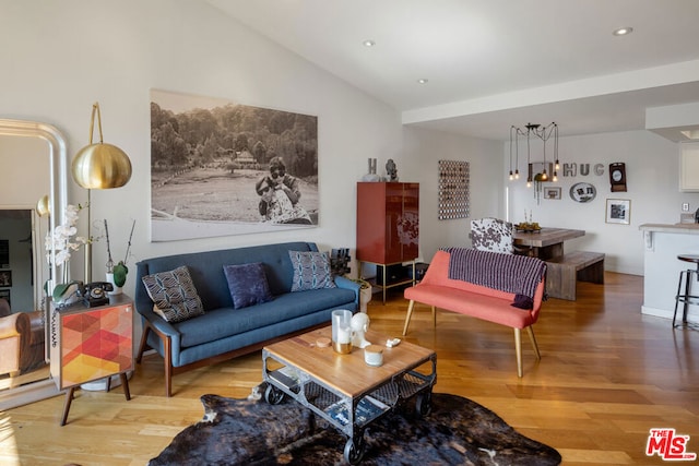 living room featuring lofted ceiling and light hardwood / wood-style floors