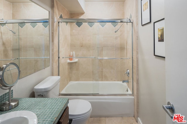 full bathroom with toilet, vanity, and bath / shower combo with glass door