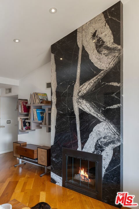 interior details featuring hardwood / wood-style flooring and a fireplace