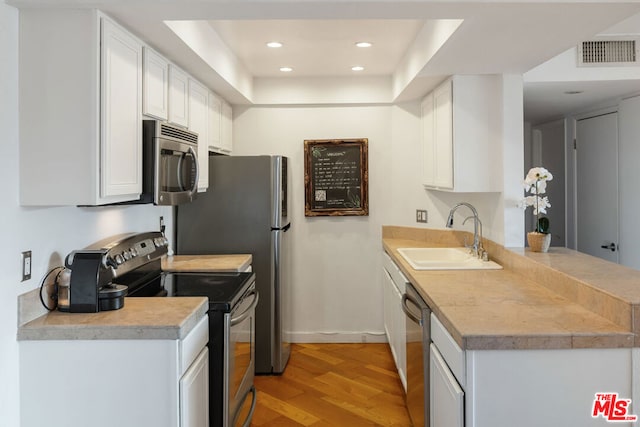 kitchen with white cabinetry, sink, light hardwood / wood-style flooring, and stainless steel appliances