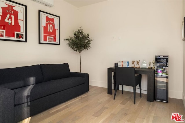 office featuring wine cooler, a wall mounted air conditioner, and light hardwood / wood-style flooring