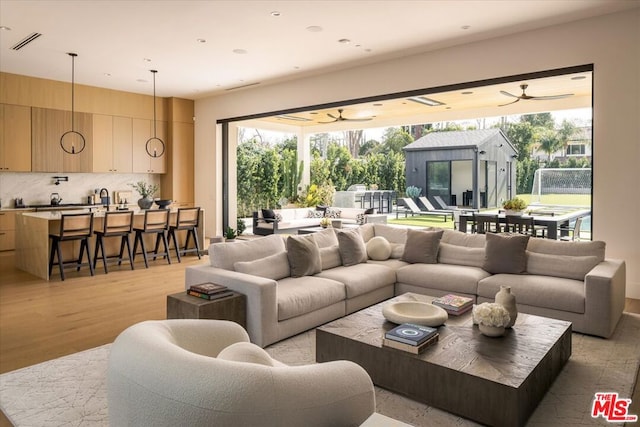 living room with ceiling fan and light hardwood / wood-style floors