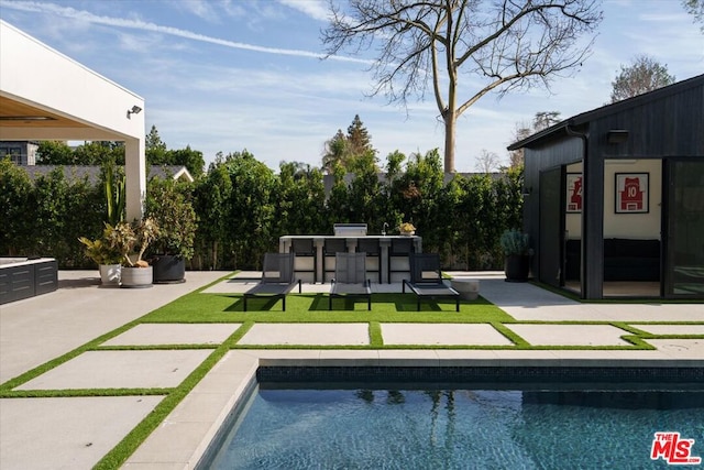 view of pool with exterior bar and a patio area