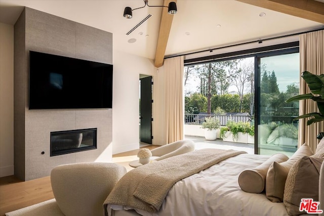 bedroom featuring hardwood / wood-style flooring and a tile fireplace