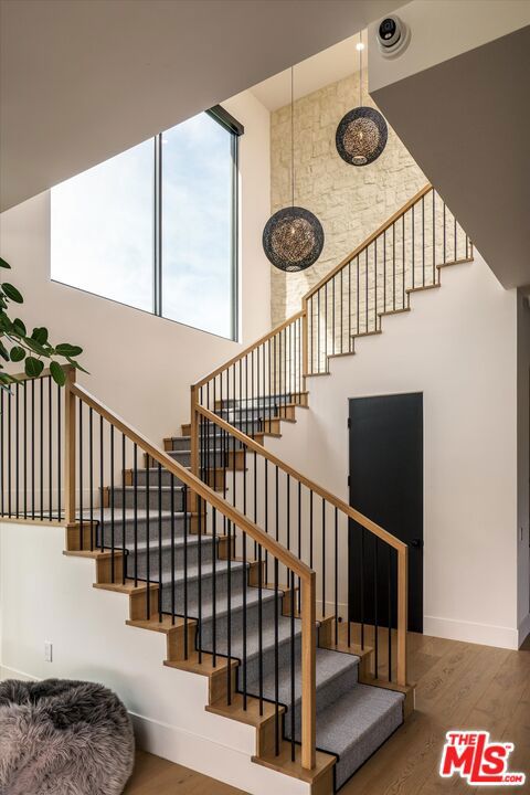 staircase featuring hardwood / wood-style floors and a high ceiling