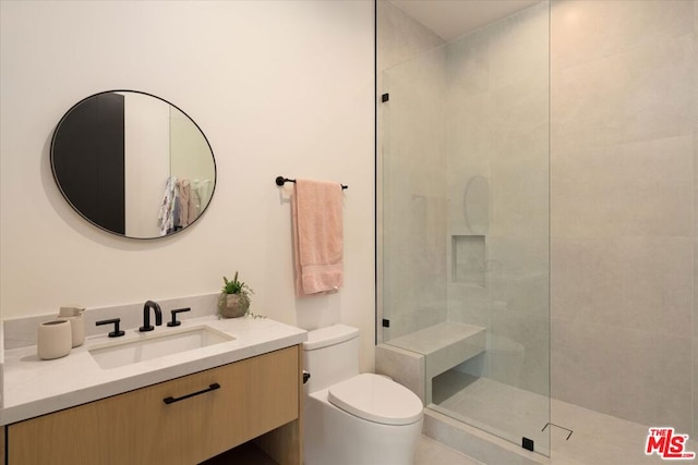 bathroom featuring vanity, toilet, and a tile shower