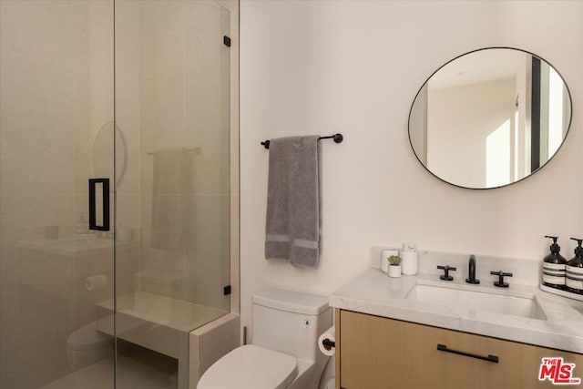 bathroom with vanity, an enclosed shower, and toilet