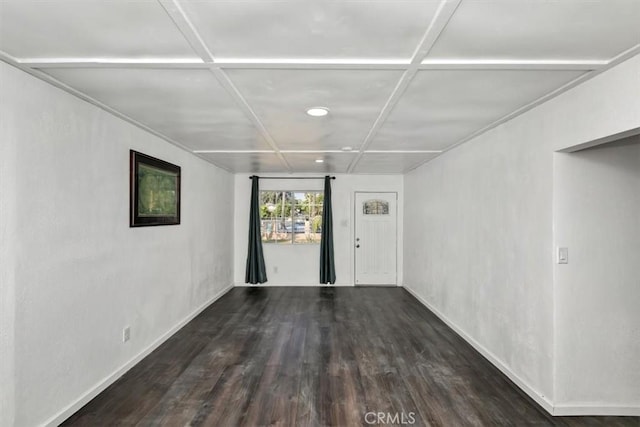 unfurnished room featuring dark wood-type flooring and coffered ceiling