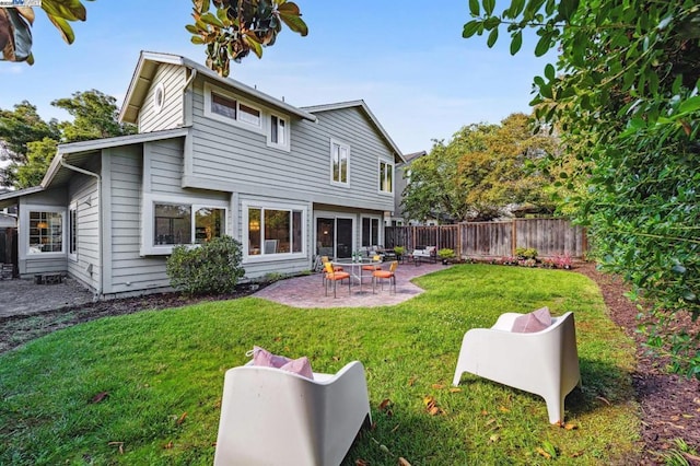 rear view of property with a yard and a patio area