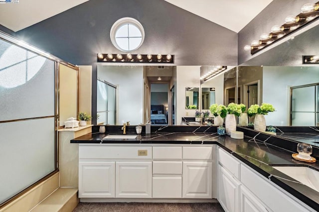 bathroom featuring a shower with door, vanity, and lofted ceiling