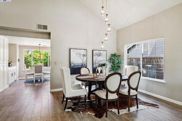 dining room featuring dark wood-type flooring and high vaulted ceiling