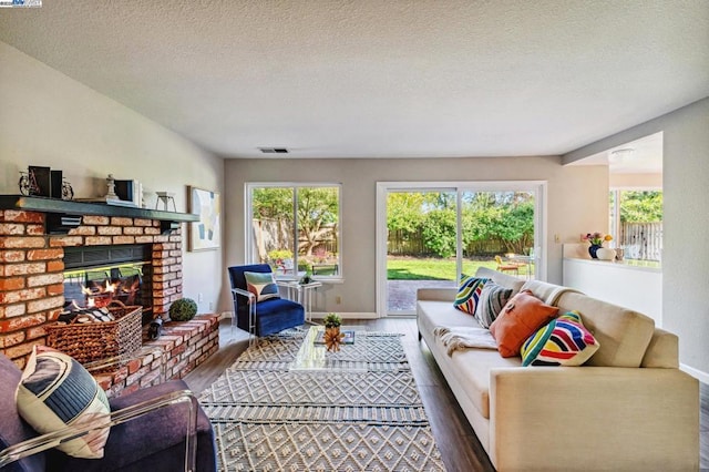 living room featuring a fireplace, hardwood / wood-style floors, and a textured ceiling