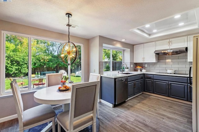 kitchen featuring gray cabinetry, white cabinetry, dishwasher, black electric stovetop, and backsplash