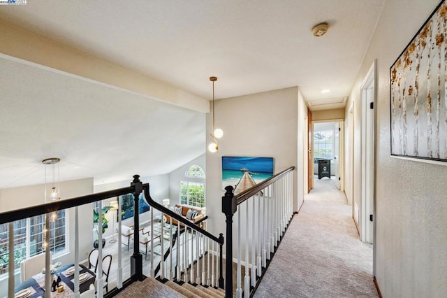 hall with light carpet and vaulted ceiling with beams