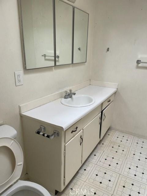 half bathroom featuring vanity and toilet