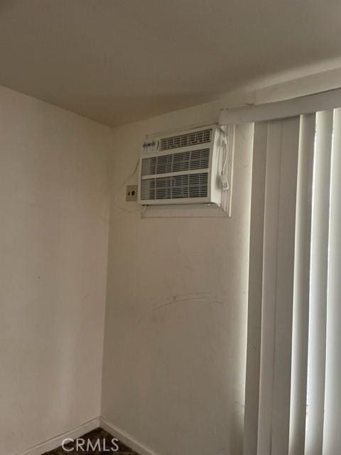 interior space with a wall mounted AC and baseboards