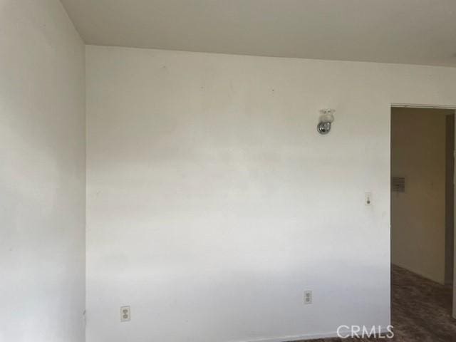 spare room featuring dark colored carpet