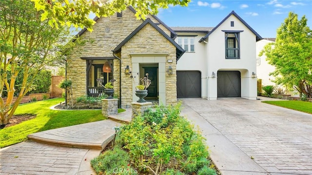 19 Basilica Pl, Ladera Ranch, CA 92694 - view of front of house with driveway, stone siding, an attached garage, a front lawn, and stucco siding