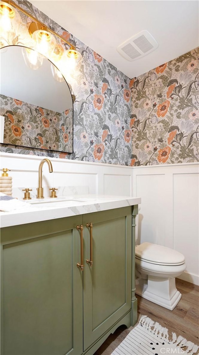 19 Basilica Pl, Ladera Ranch, CA 92694 - half bath with wallpapered walls, a wainscoted wall, vanity, wood finished floors, and a decorative wall