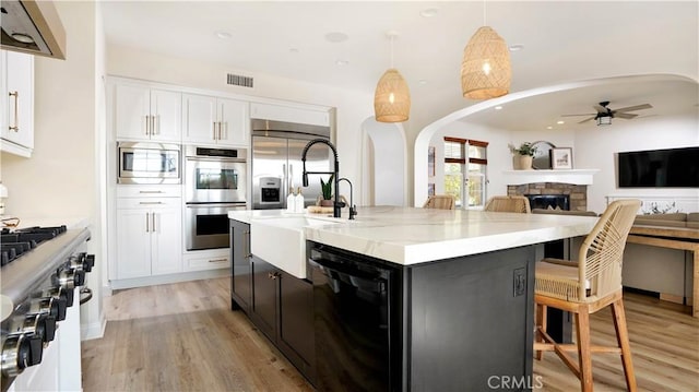 19 Basilica Pl, Ladera Ranch, CA 92694 - kitchen featuring built in appliances, arched walkways, ceiling fan, light wood-style flooring, and recessed lighting