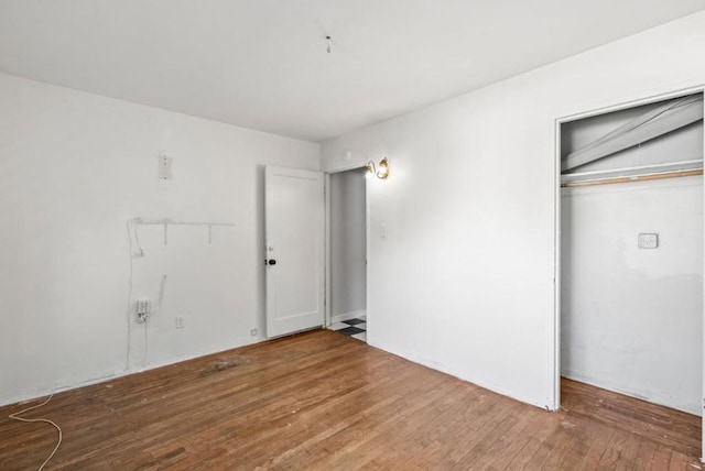 unfurnished bedroom with wood-type flooring and a closet