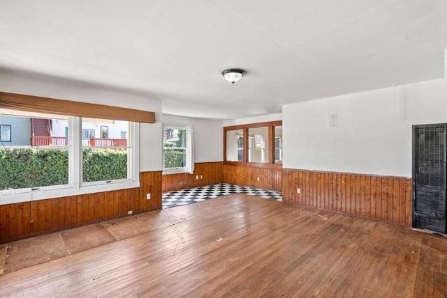 empty room featuring wood-type flooring and wooden walls